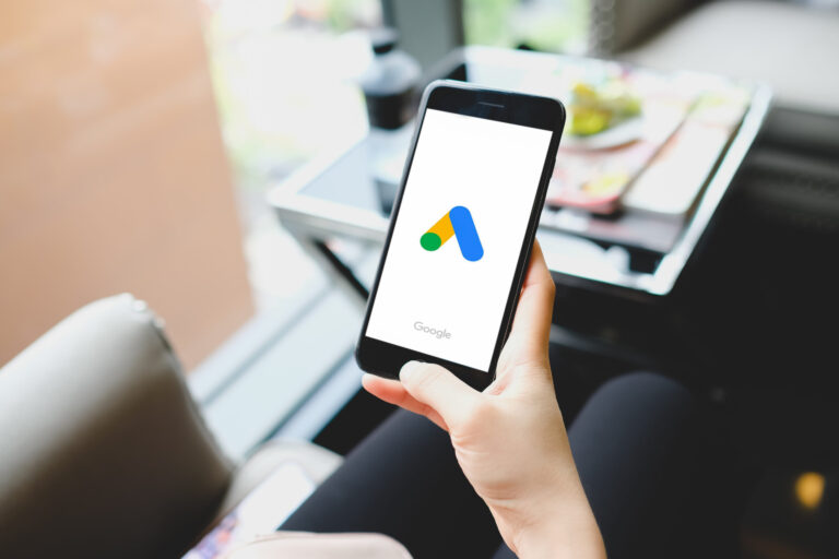 Móvil mostrando el logo de Performance Max de Google Ads como representación de campañas automatizadas con inteligencia artificial